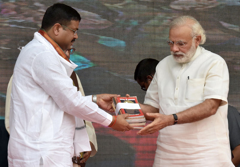 Dharmendra Pradhan offering book Narendra Modi